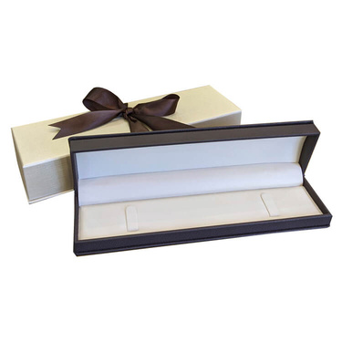 Long, dark brown hinged jewelry box showcasing a line bracelet gently secured and beautifully displayed